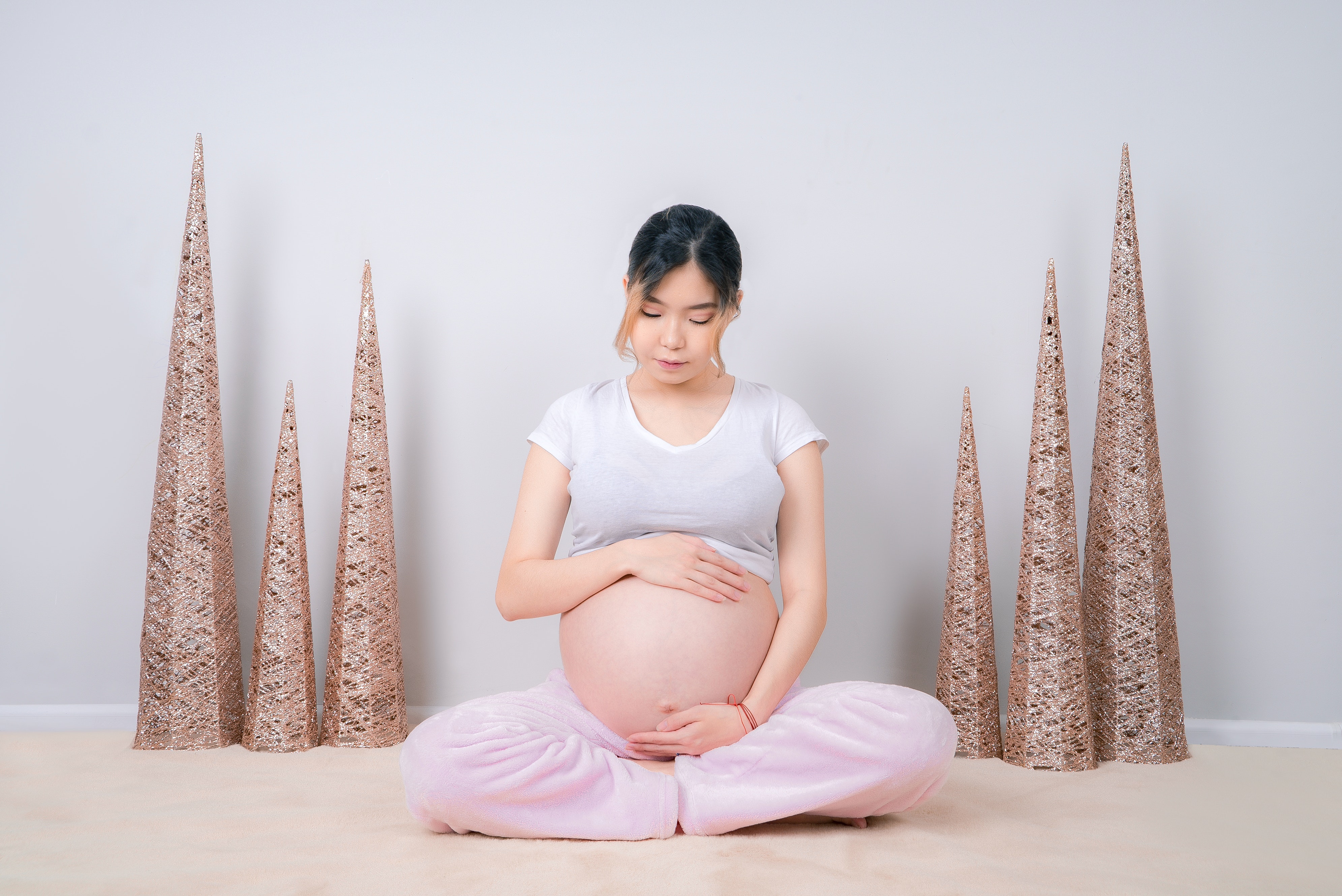 woman-showing-her-baby-bump-while-sitting-on-floor-3596662
